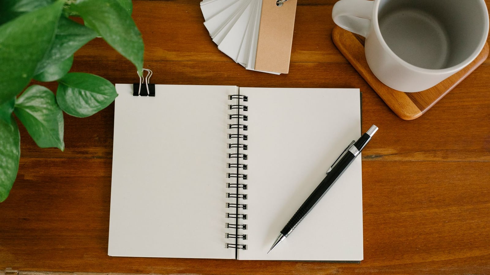 A minimal workspace with a planner and laptop, illustrating content briefing